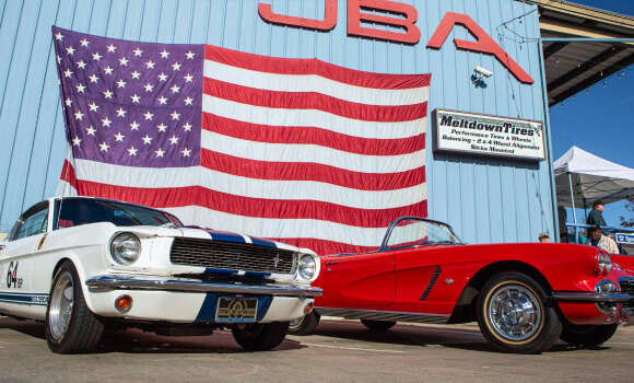 JBA Speed Shop headquarters with American flag and classic Mustangs