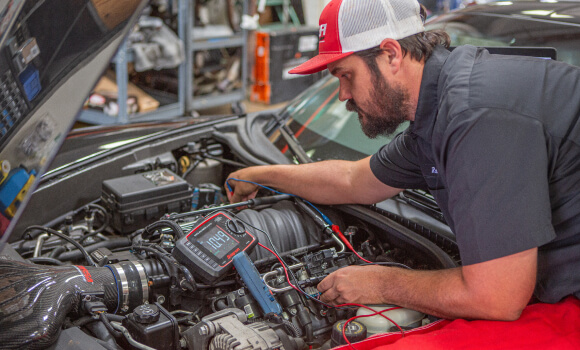 A JBA technician working on a car