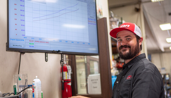 A JBA technician standing in front of a computer with a graph on it